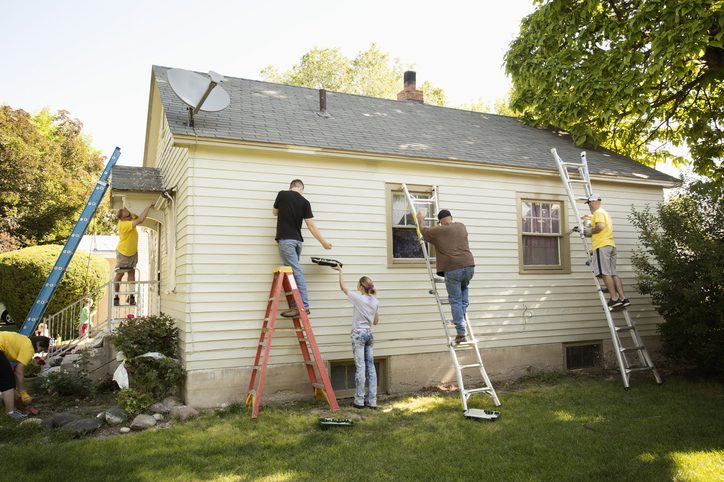 People painting outside of house