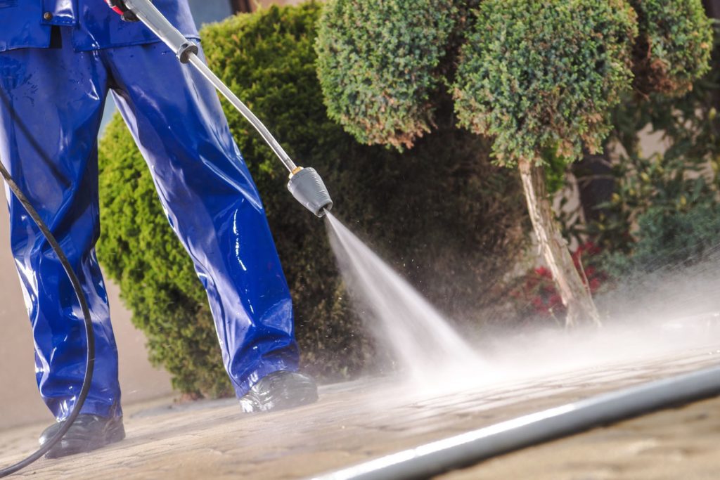 Close up of a man pressure washing outside